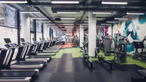 Large group of exercise machines in an empty gym.